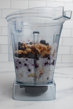 Blueberry smoothie ingredients in a blender.
