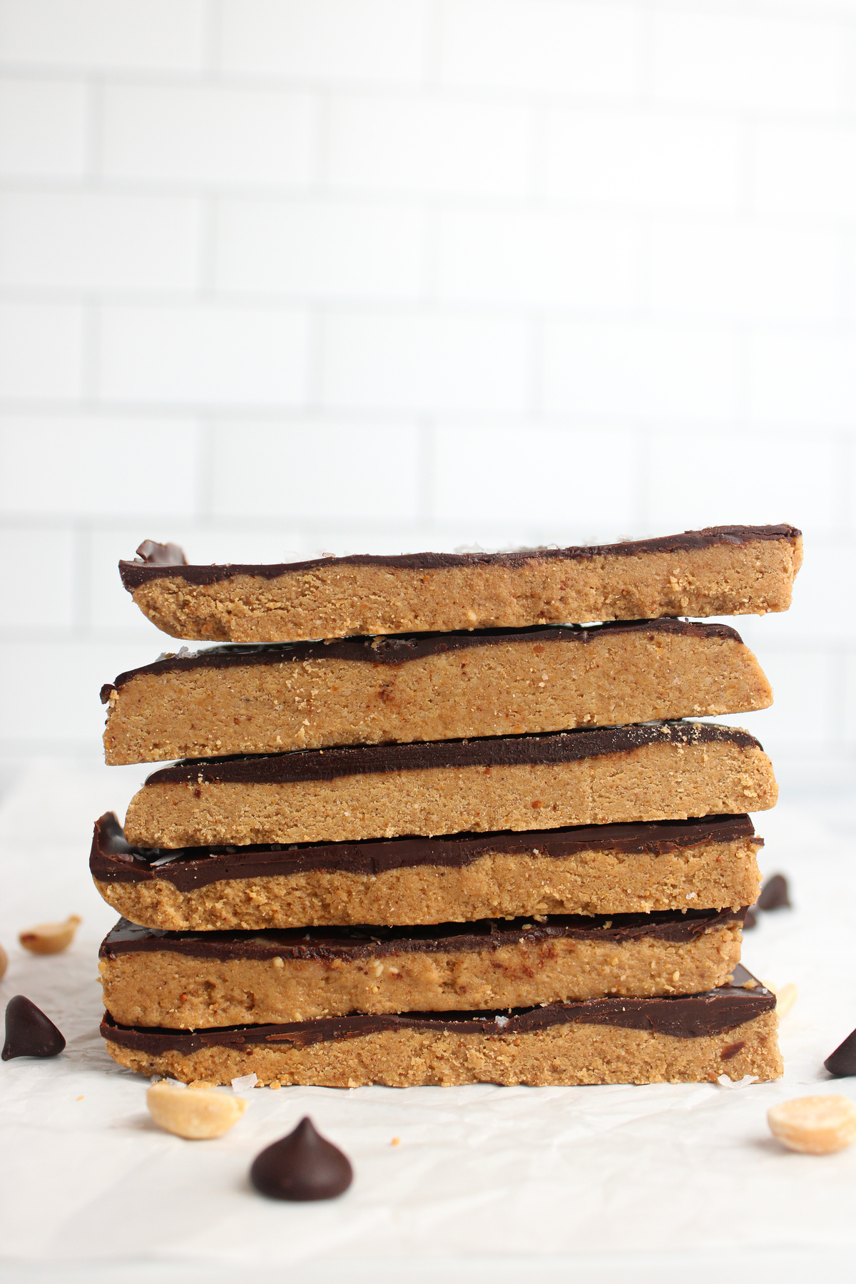 Tall stack of six chocolate peanut butter protein bars, highlighting layers and texture.