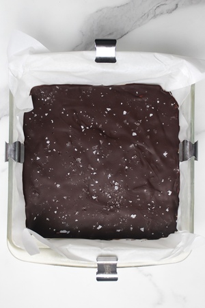 Peanut butter and chocolate layers chilled in the fridge, chocolate hardened, topped with flaky sea salt.