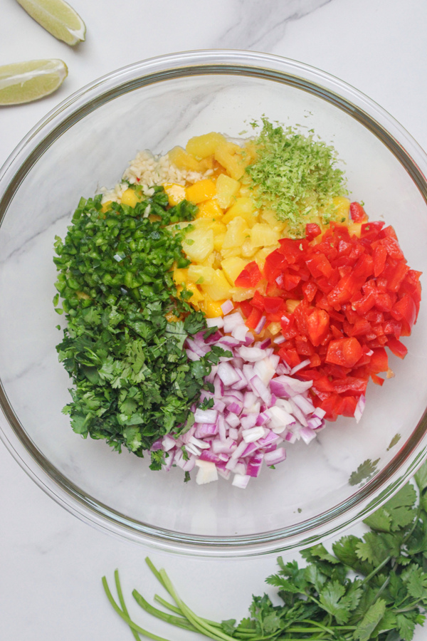 All ingredients for mango pineapple salsa combined in a bowl.