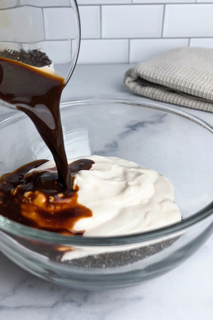 Chia seeds, non-dairy yogurt, espresso, and maple syrup combined in a bowl.
