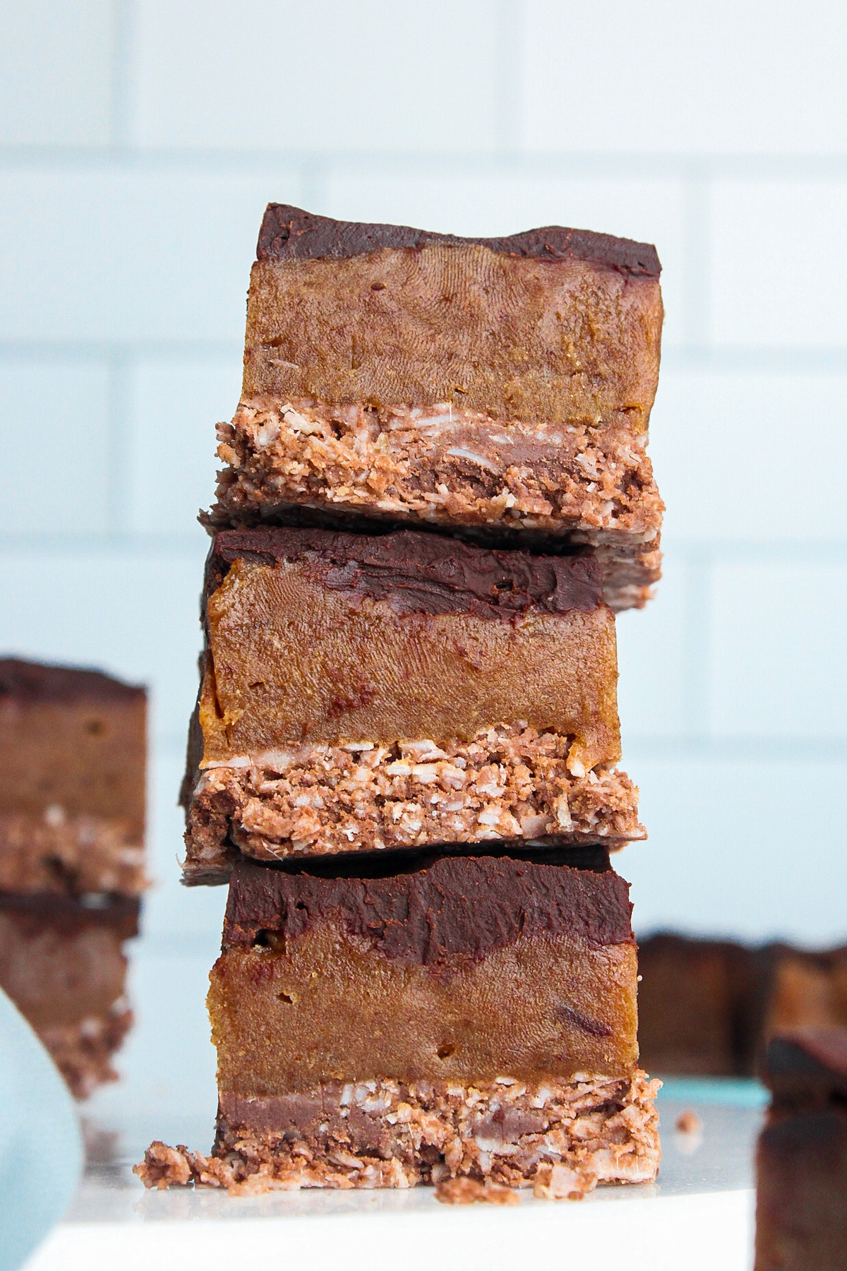 Closeup stack of three no-bake chocolate caramel slices.