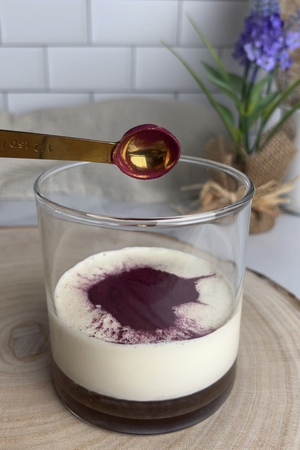 Vegan heavy cream, oat milk, lavender syrup, and acai powder combined in a glass.