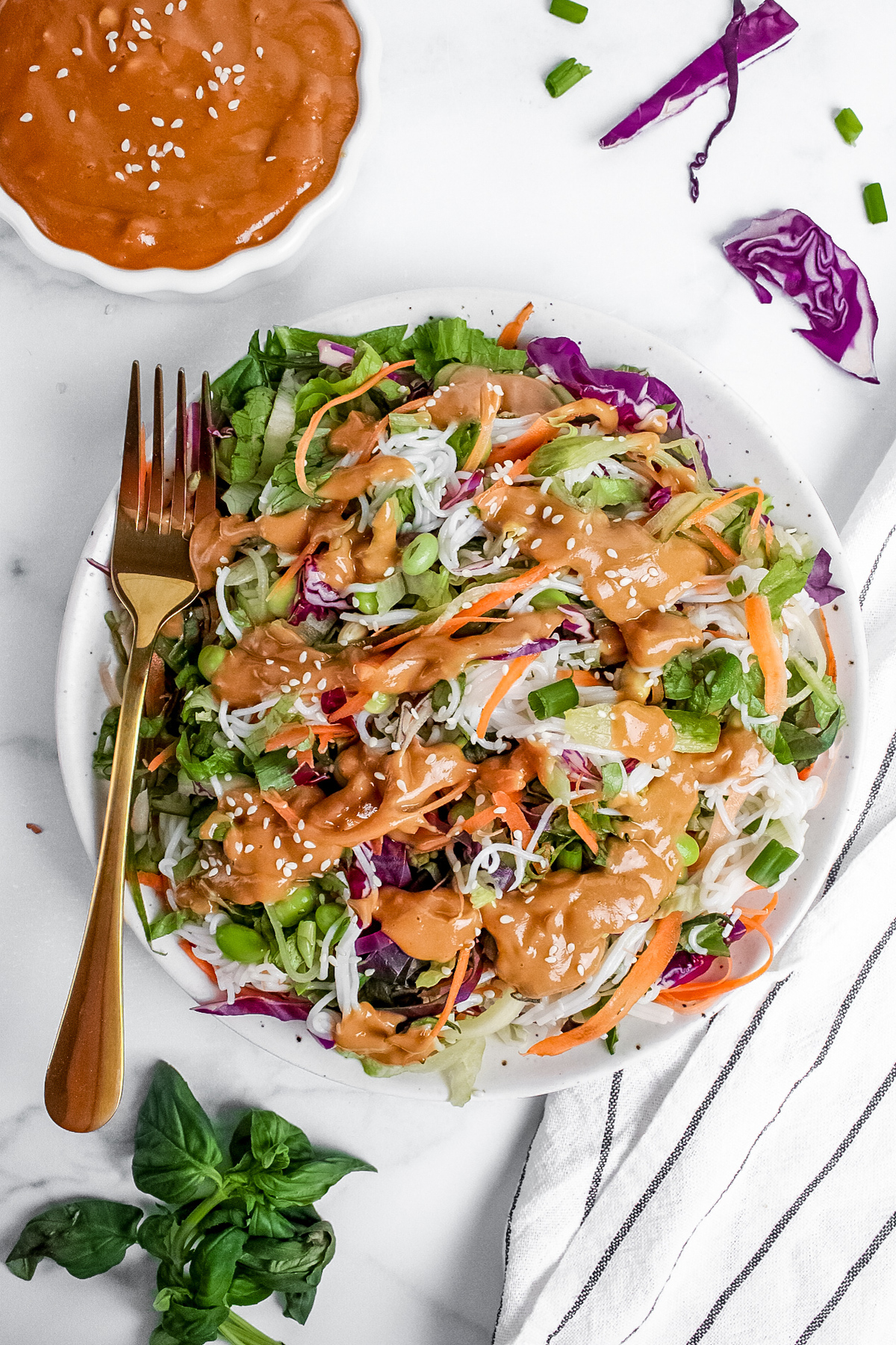 Spring roll–inspired salad served on a plate with peanut dressing and a fork.