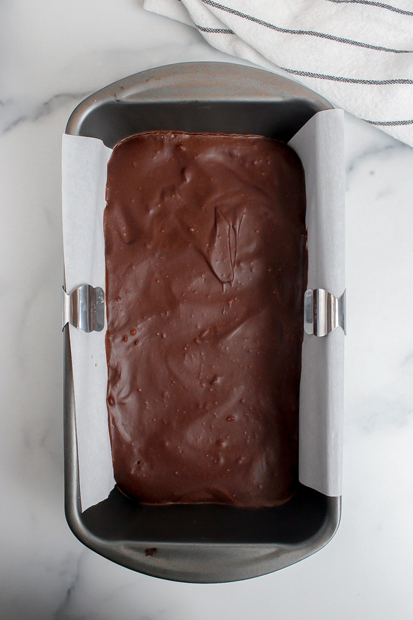 Chilled chocolate ganache on cookie dough bars, ready to be sliced.