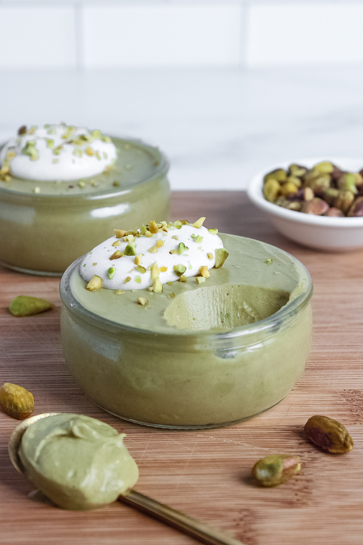 Dairy-free pistachio mousse with a bite taken out with a spoon, showing its luxurious, creamy texture.