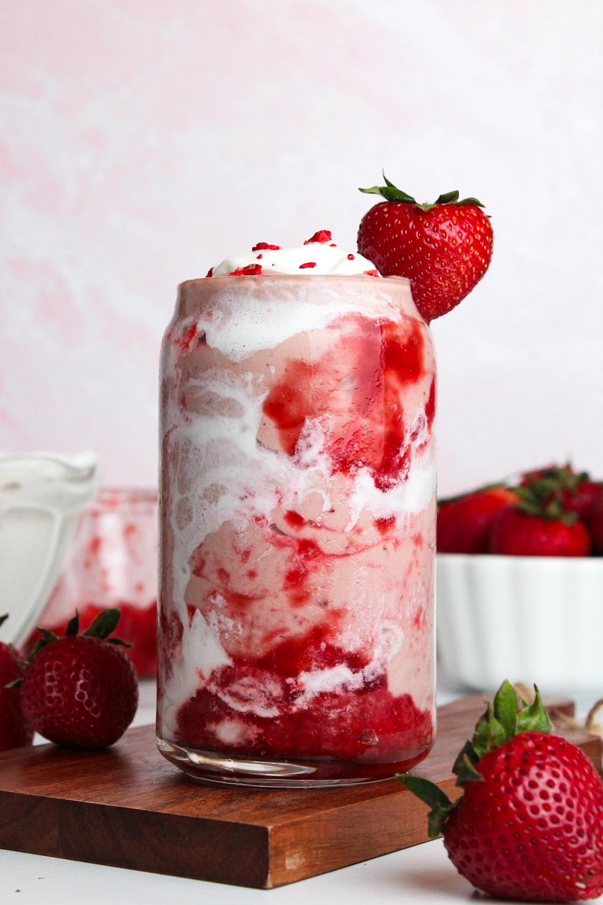 Straight-on view of a strawberry glaze smoothie showing layered swirls of strawberry glaze and coconut cream.
