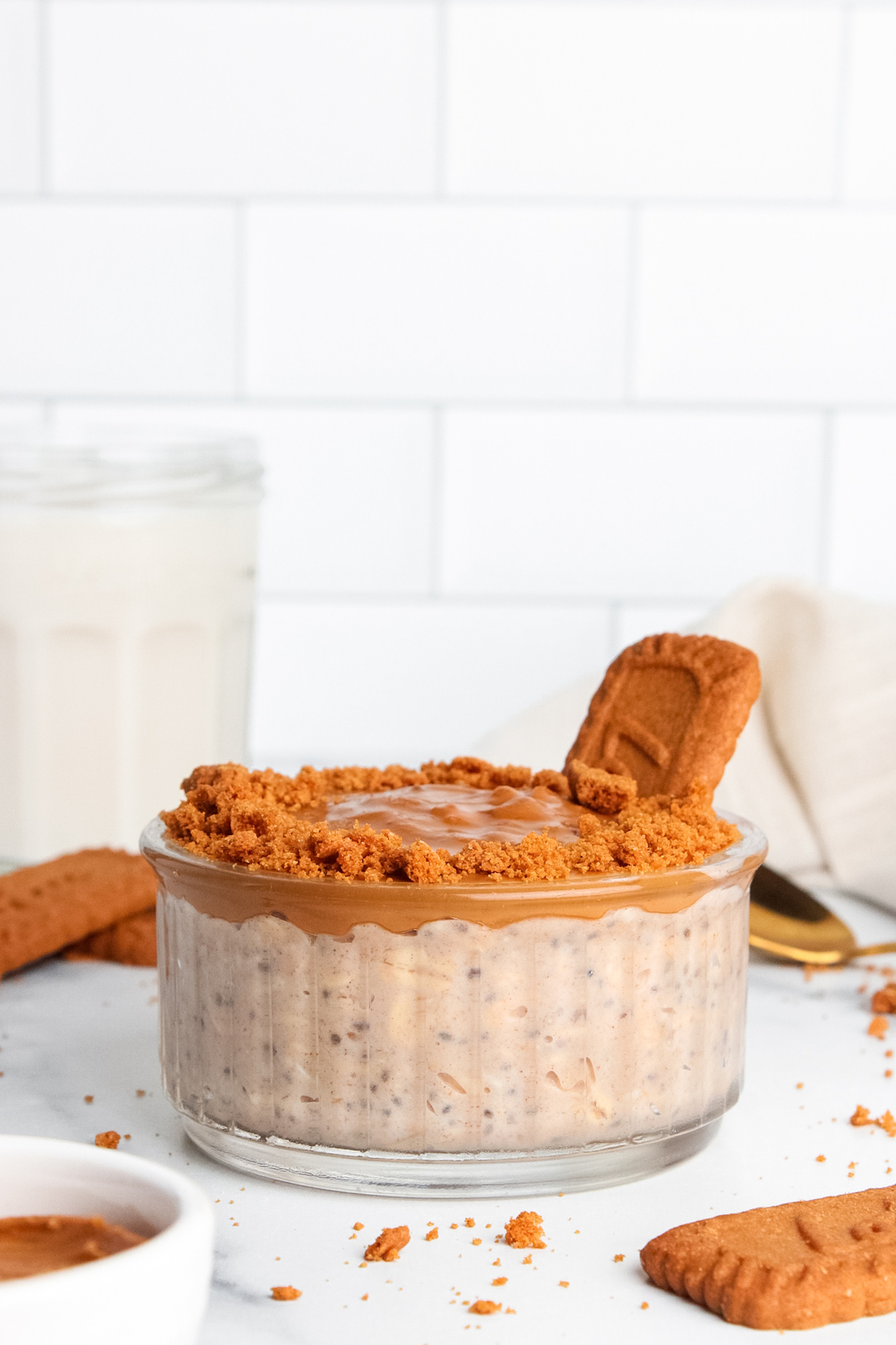 Creamy, high-protein Biscoff overnight oats topped with cookie butter and crushed cookies.