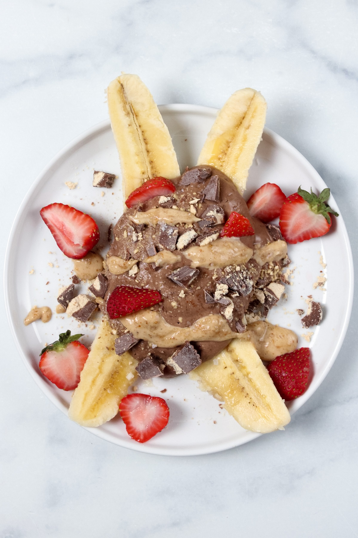 Breakfast banana split topped with chocolate yogurt, chopped chocolate, peanut butter, and strawberries for a different variation.
