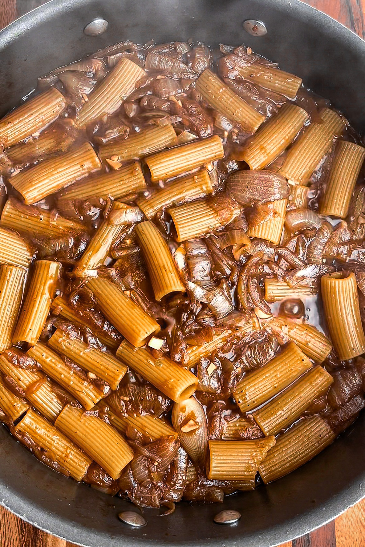 Short-cut pasta cooking in the pot as the broth reduces into a creamy sauce.