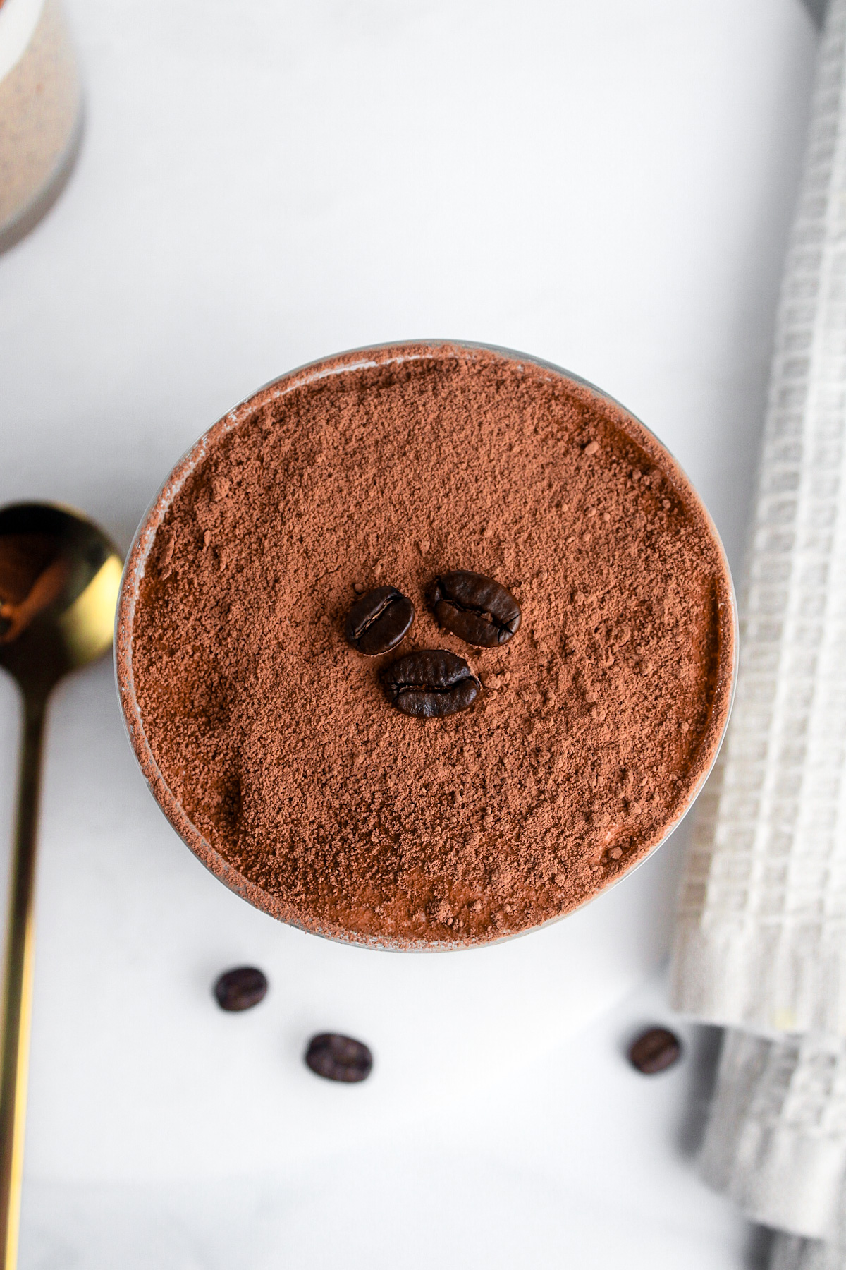 Overhead close-up of tiramisu chia pudding topped with cocoa powder.