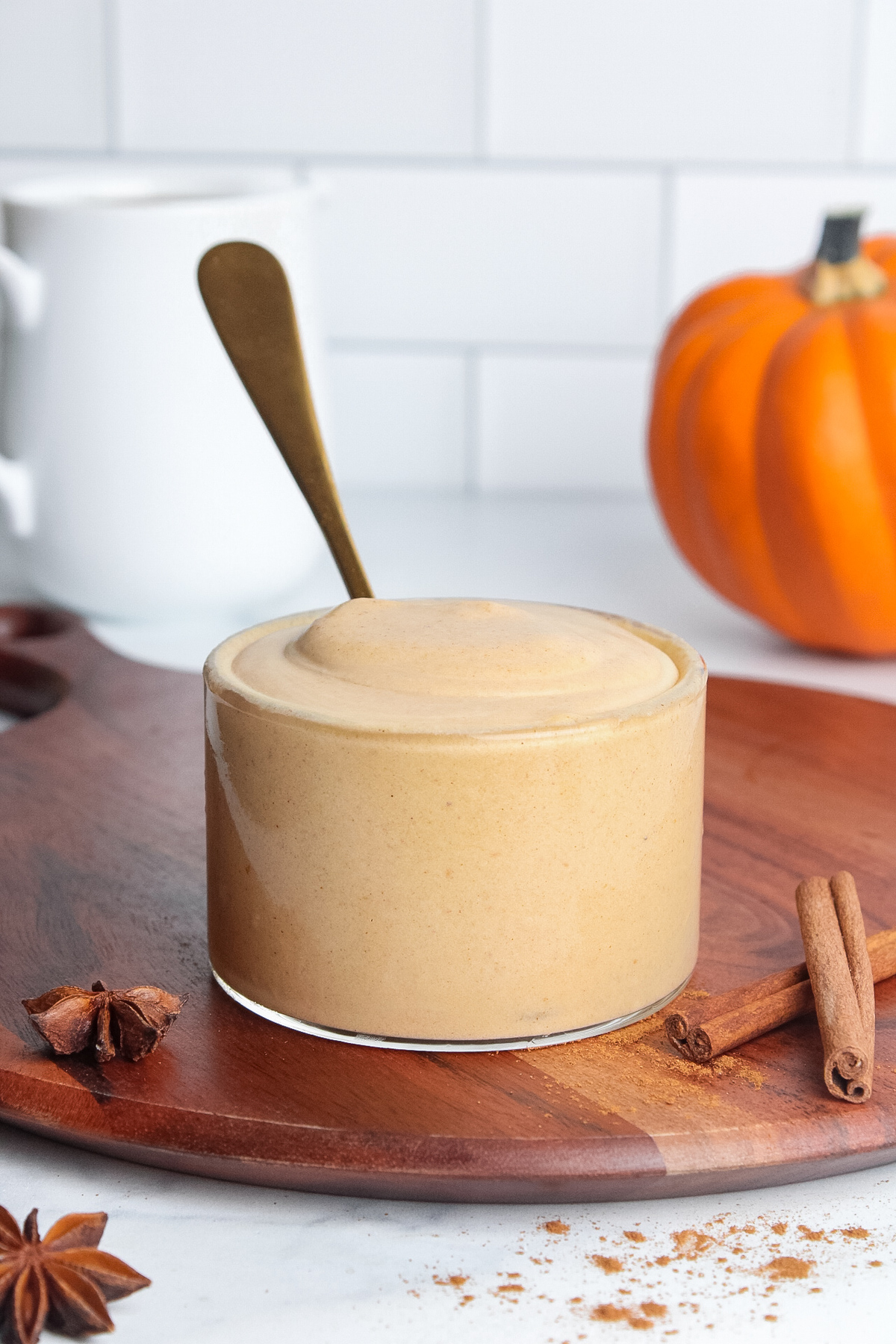 Glass of creamy dairy-free pumpkin cream cold foam, with a spoon in it.