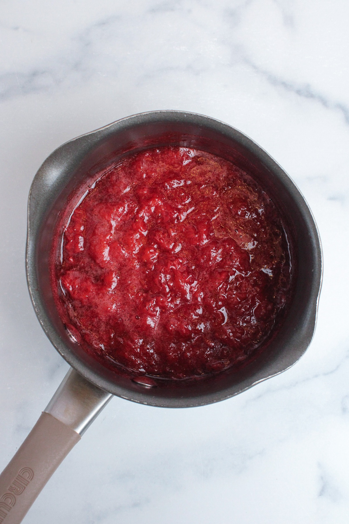 Finished strawberry glaze in a saucepan after cooking and reducing.